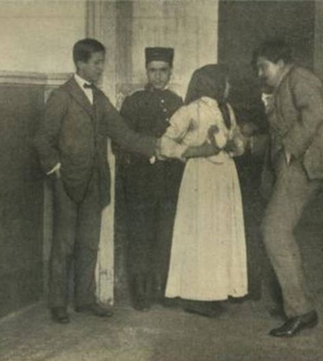 A historic photograph depicting two men and a woman in 19th-century attire, with a police officer standing nearby, suggesting an interaction or investigation.